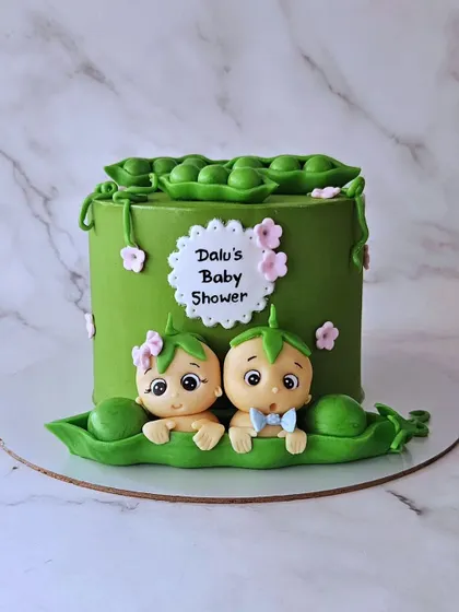 Two peas in a pod! A unique baby shower cake for a mother expecting twins. This chocolate truffle cake features two adorable babies nestled in pea pods.