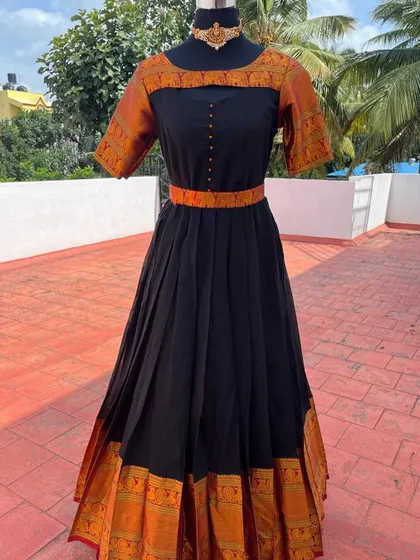 A full-length view of the black and orange traditional gown.