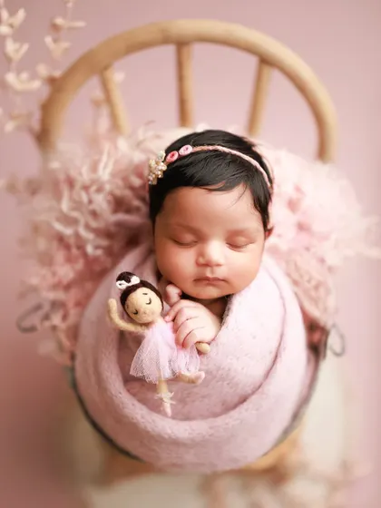 Another take on pretty in pink. This little ballerina, complete with a tiny doll, looks so sweet wrapped in a soft pink knit and nestled in a bucket chair.