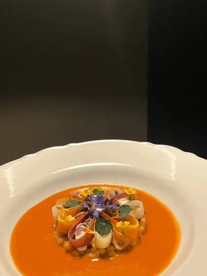 A vibrant vegetarian main course of pearl couscous cooked with Indian spices, served with confit topinambur and a velvety tomato shorba.