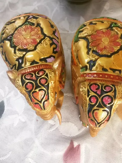 A pair of wooden elephant statues that I hand-painted with intricate details. The golden finish is highlighted with colorful floral and animal carvings, making them a royal decor accent.
