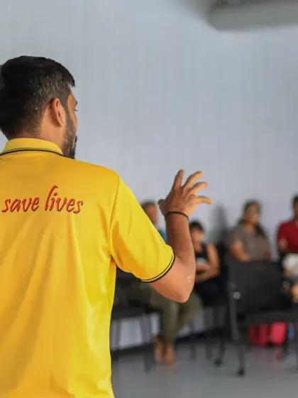 The back of an instructor's shirt reads "We save lives," perfectly capturing the mission of our CPR and first aid training workshops.