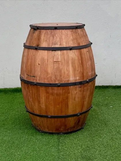 A single rustic wine barrel, perfect for use as a decorative element, a stand for floral arrangements, or as a simple cocktail table.