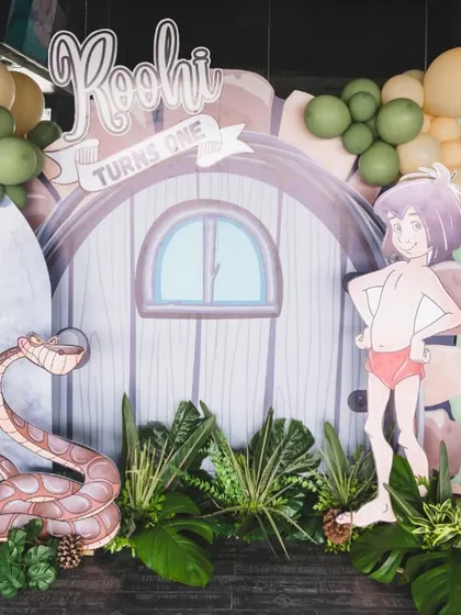 A full view of the Jungle Book backdrop, featuring Mowgli and Kaa, with a "Roohi Turns One" sign, creating a perfect photo opportunity.