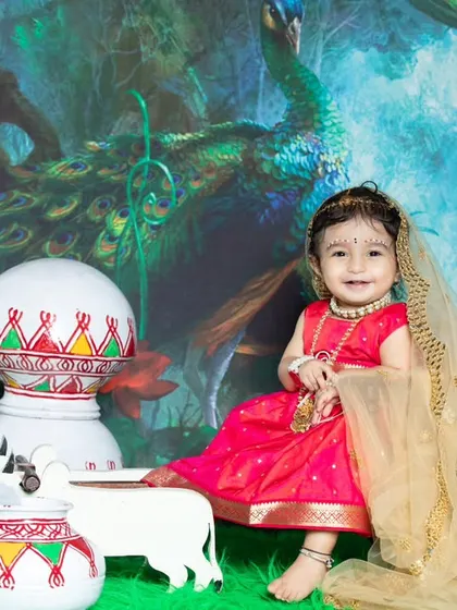 This little Radha is sitting gracefully, with a peacock and matkas in the background.