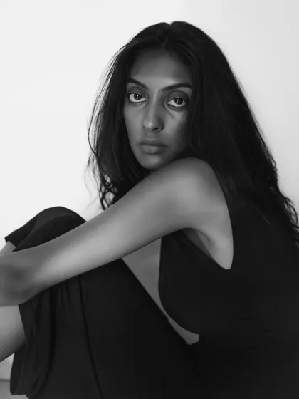 A simple and honest black and white portrait. The lack of elaborate styling or lighting puts the focus entirely on the model's natural beauty and expression.