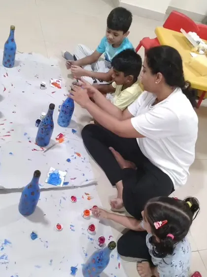 A group of children completely absorbed in a bottle painting activity. This hands-on project is always a favorite at our camps.