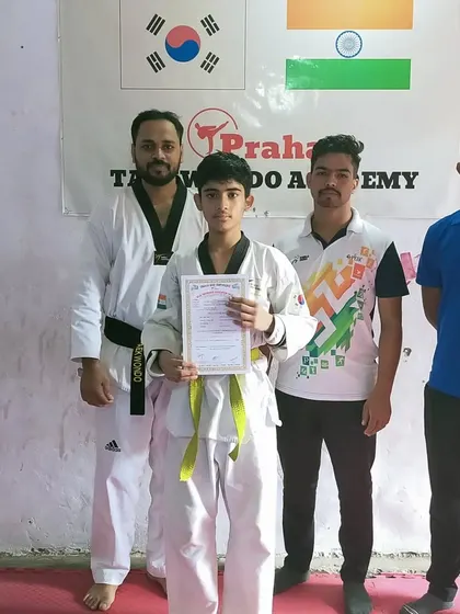 A yellow belt student with his first Taekwondo certificate, a keepsake he will cherish for years.