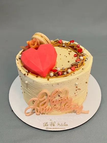 This "wreath of love" cake is perfect for an anniversary. It features a geometric chocolate heart, a buttercream wreath, and a custom "Happy Anniversary" sign.