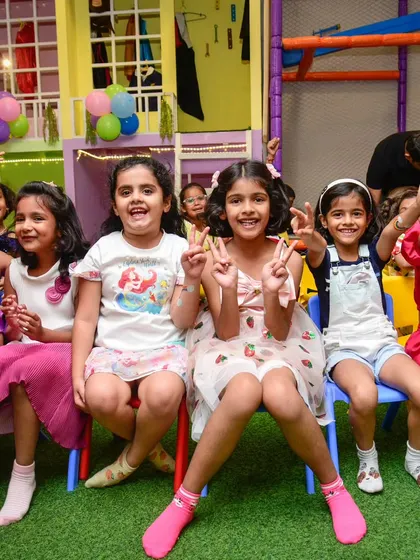 A group of happy girls posing for a photo, flashing peace signs and big smiles. This is what a fun day with friends looks like.