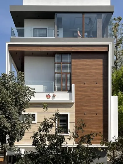 This facade emphasizes verticality, with large glass windows and a prominent wood-clad section that adds warmth and character to the contemporary design.