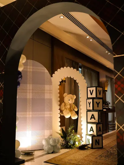 We created a charming photo corner near the entrance, featuring a teddy bear on a scalloped arch and personalized letter blocks. The plaid backdrop ties in perfectly with the classic polo theme of the birthday party.