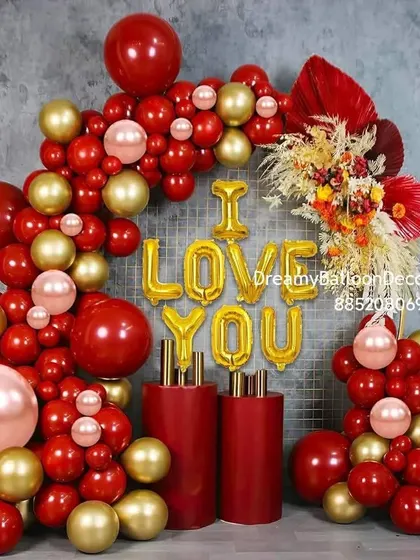 A luxurious 'I Love You' setup in red and gold. This balloon arch is perfect for proposals, anniversaries, or Valentine's Day, featuring rich colors and dried flower arrangements.