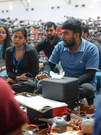 A team leader briefs the crew amidst racks of drones. Collaboration and clear communication are key to our success, ensuring every member of the BotLab family is in sync.
