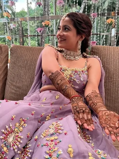 A beautifully dressed bride-to-be at her mehndi ceremony, looking radiant with her full bridal henna.
