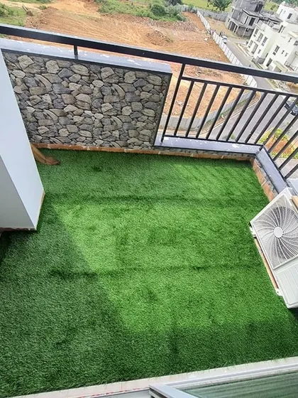 A wide shot of the balcony with the new artificial grass floor, ready for the client to add plants and furniture.