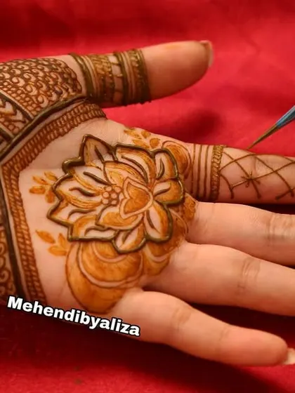 A close-up of me in action, drawing a lotus with one of my fresh henna cones. Every design starts with a single, careful stroke.