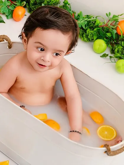 Sunny, bright, and everything nice. A close-up of a baby enjoying a citrus-filled milk bath, a unique and beautiful milestone session.