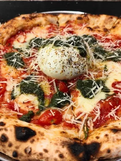 A true showstopper, my Burrata Pesto Pizza. I top a classic Neapolitan base with fresh pesto and a whole creamy burrata right in the center. It's a gourmet pizza experience that your guests will be talking about long after the party ends.