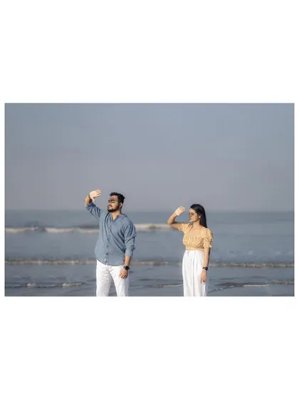 A fun and quirky pose by the ocean, showing the couple's playful personality.