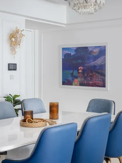 A detail of the dining area, where a painting commands attention. The space is designed with a calming blue palette and ocean-themed artwork to evoke tranquility.