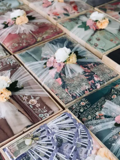 A stunning collection of trousseau gifts, including a tray with artfully arranged cash. Each box is packed to perfection, reflecting the grandeur of the occasion.