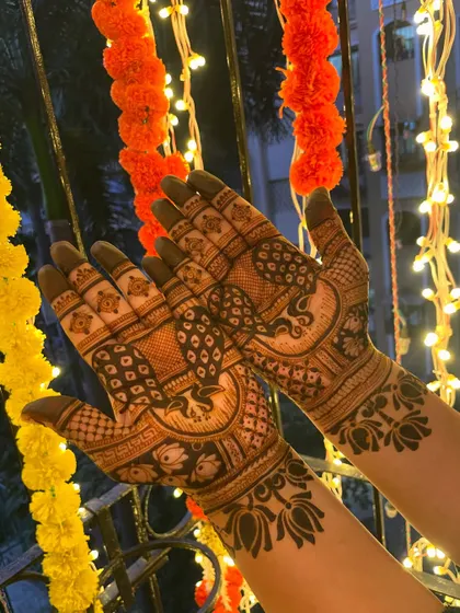 A festive design with peacocks and lotus flowers. The bright background makes the dark henna stain pop.