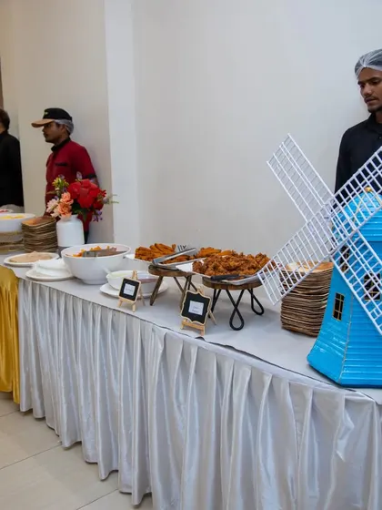 A well-stocked buffet line at a corporate event, featuring a variety of snacks. The setup includes a decorative windmill, adding a touch of whimsy to the presentation.