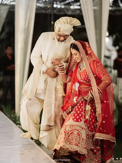 The groom helps his bride navigate the steps, a small gesture of care and support on their big day.