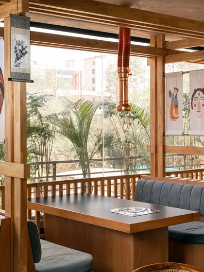 We incorporated traditional Korean art, like these hanging scrolls and masks, to infuse the space with cultural identity. These elements, set against the clean lines of the wooden booths, create a beautiful dialogue between heritage and modernity.