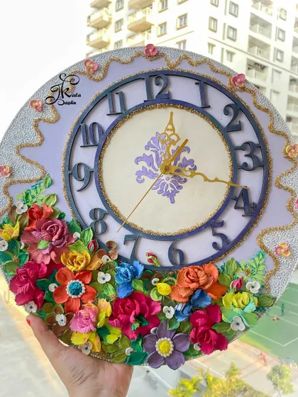 A unique wall clock with a lavender base and a distinct inner dial. The piece is decorated with a garden of colorful flowers, making it a wonderful custom gift that I created for my bhabhi and bhaiya.