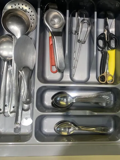A cutlery drawer where we've used a tray insert to create specific compartments for different types of spoons, whisks, and scissors.