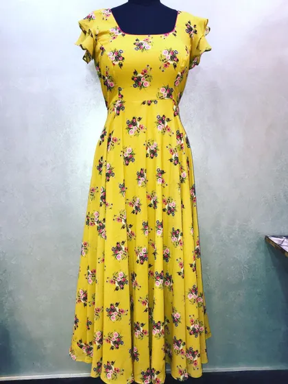 A custom-stitched long floral dress in yellow. This anarkali-style dress has a simple neckline and flutter sleeves, with a focus on perfect fitting.