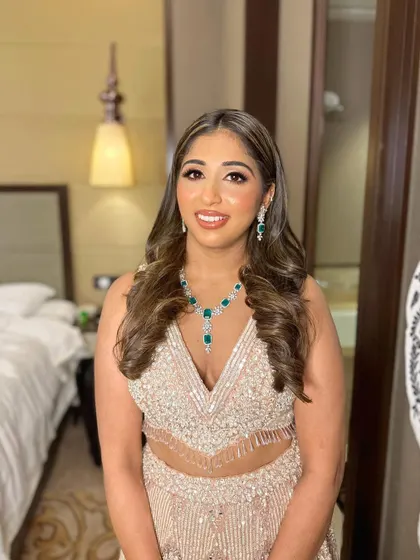 A full portrait showing how the makeup ties into her sparkling lehenga and emerald necklace.
