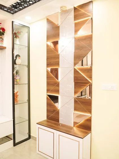 A stylish partition with geometric cutouts in wood and mirror, backlit to create a stunning visual effect. This piece serves as both a divider and a work of art.