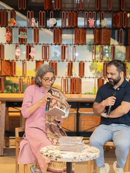 Author Mini Menon reads from her poetry book, "A Fly on The Wall," during her launch event, with our host listening intently.