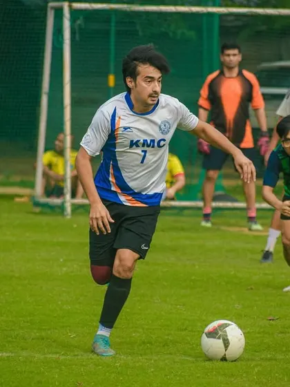 A player dribbles forward, looking to break the deadlock in a competitive corporate match.