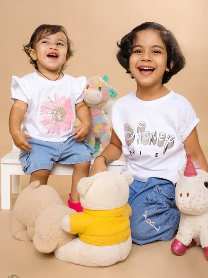 Pure happiness between two sisters surrounded by their favorite toys. Our studio sessions are designed to be fun for kids, allowing us to capture their genuine laughter and personalities.