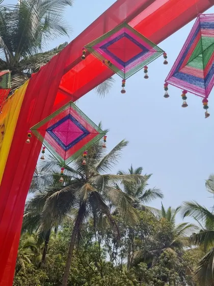 A low-angle shot of the decorative hangings against the clear blue sky and palm trees, capturing the perfect outdoor party vibe.