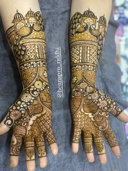 A lovely three-fourths length design. It provides beautiful coverage up the arm with traditional peacock and palace motifs, perfect for brides who want an elaborate but not full-arm design.
