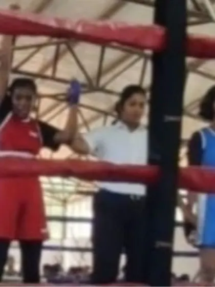 The referee raises the hand of our female fighter in victory. This moment is a culmination of her hard work and our dedicated coaching.