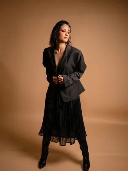 This pose from the 'FLOR' series shows the versatility of the blazer, worn as a dress-like garment.