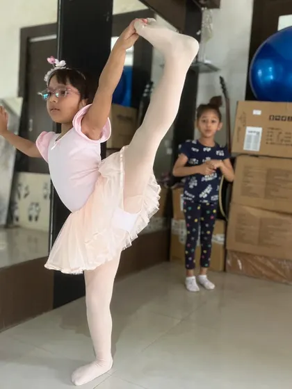 This young ballerina holds a standing split with perfect form, demonstrating the results of our dedicated ballet training in Kolkata.