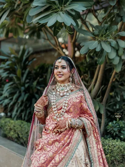 A portrait of the bride in a unique pastel-colored saree-lehenga, her elegance shining in a garden setting.