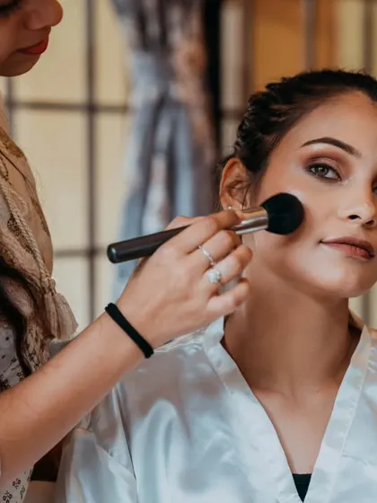The application of blush, a moment captured to show the complete process of getting ready.