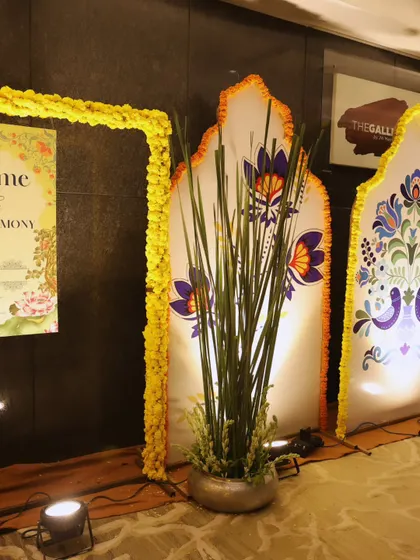 We blend tradition with modern design. This decor features backlit panels with traditional Indian motifs, framed by marigold garlands, adding a cultural touch to the entrance.