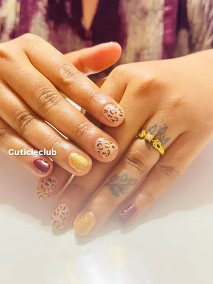 Show off your wild side with this chic animal print design on short, natural nails. I’ve combined a classic cheetah print with solid maroon and gold glitter accent nails for a look that is both trendy and sophisticated. This proves you don't need long nails to have fun with nail art.