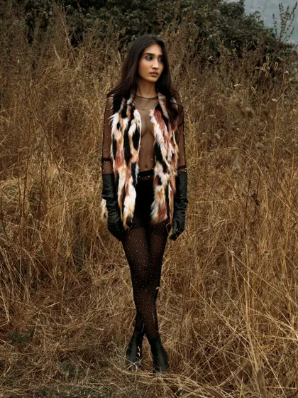 A full-length shot showcasing a high-fashion look in a wild, untamed landscape. This is great for an editorial that tells a story of adventure.