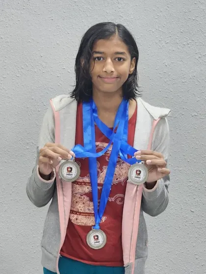 Harini shows her three silver medals won in freestyle, backstroke, and breaststroke at the Splash N' Dash interschool meet.