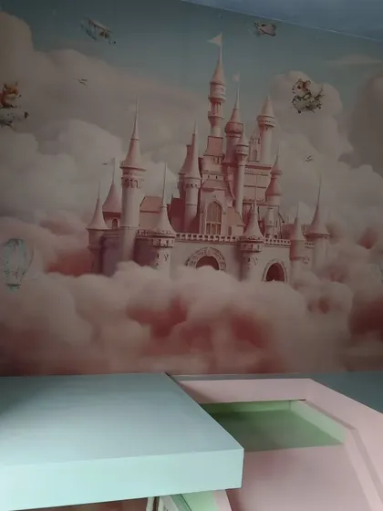 A dreamy princess castle mural surrounded by pink clouds. This wallpaper turns a bedroom into a fairytale scene.